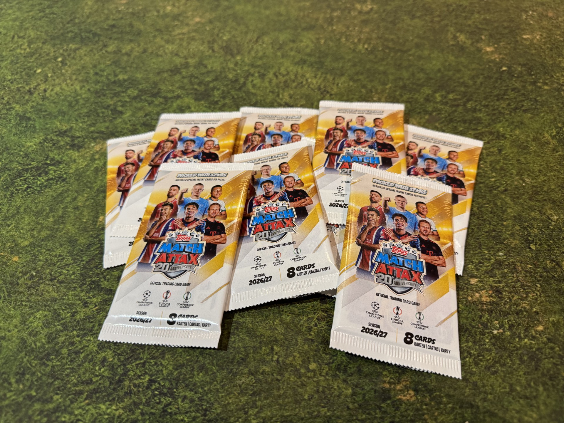 Topps Match Attax 2026/27 card packets arranged on grass